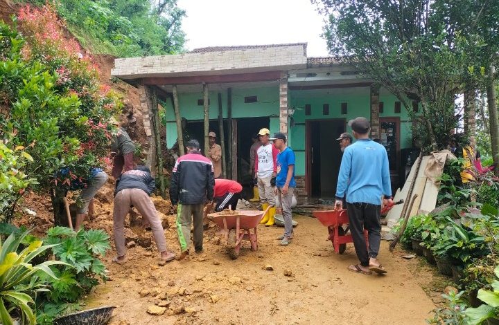 Warga bergotong-royong bersihkan material longsor.