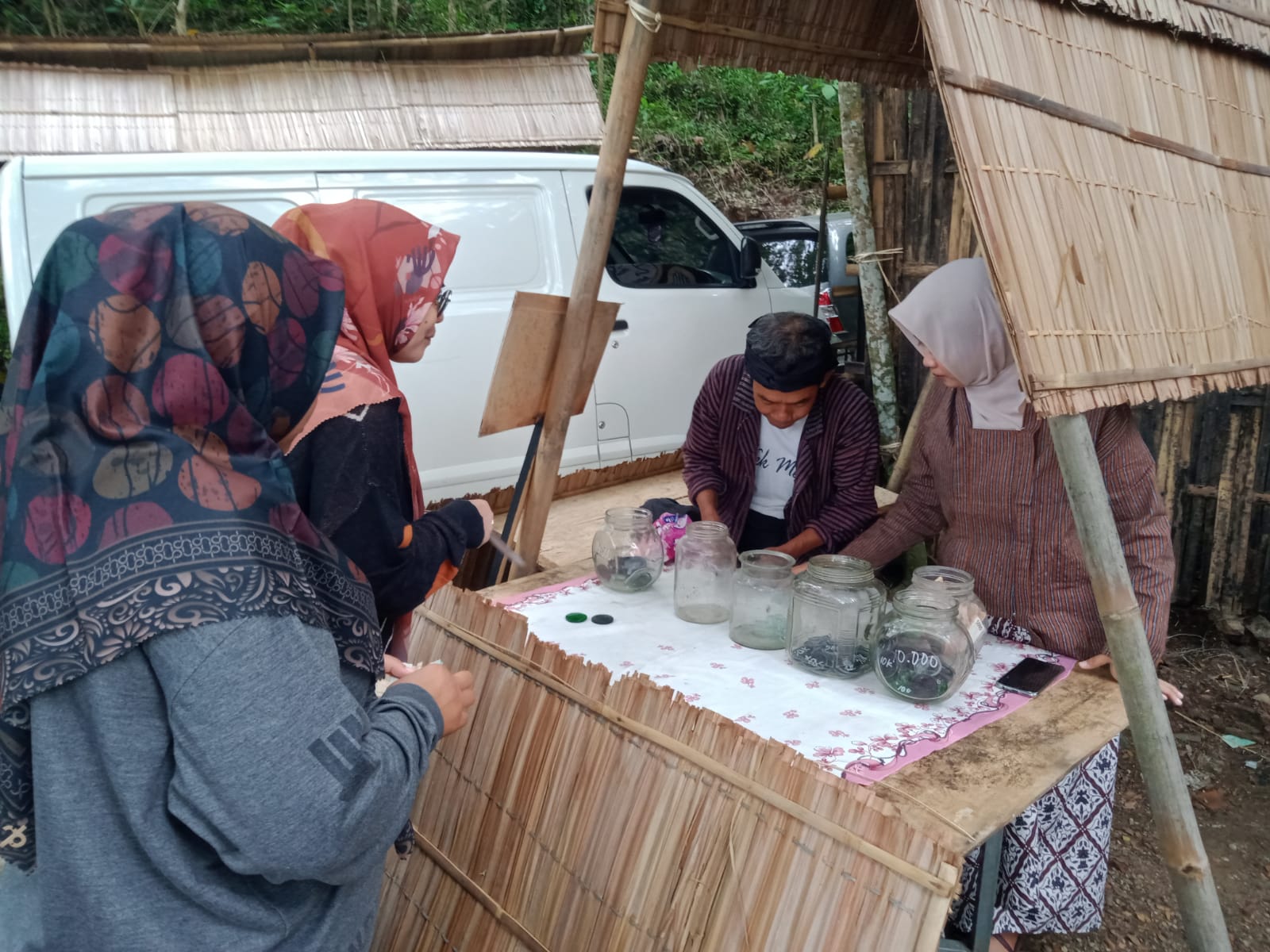 Pengunjung datang dan menukar uang tunai dengan koin dari beling. 