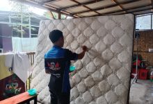 Riko saat mencuci springbed milik pelanggannya.