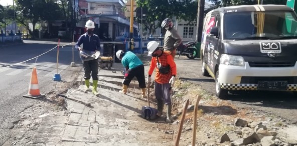 Dinas PUPR saat melakukan perbaikan plat beton yang ambles.